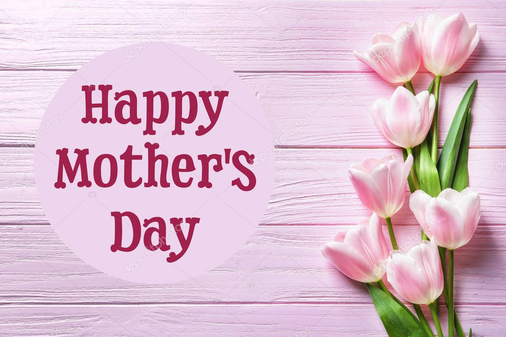 Beautiful tulips and text Happy Mother's Day on wooden background, top view