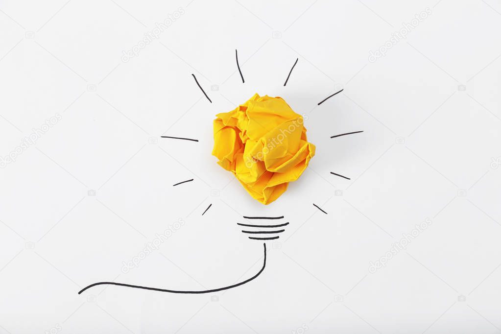 Composition with crumpled paper ball and drawing of lamp bulb on white background, top view. Creative concept