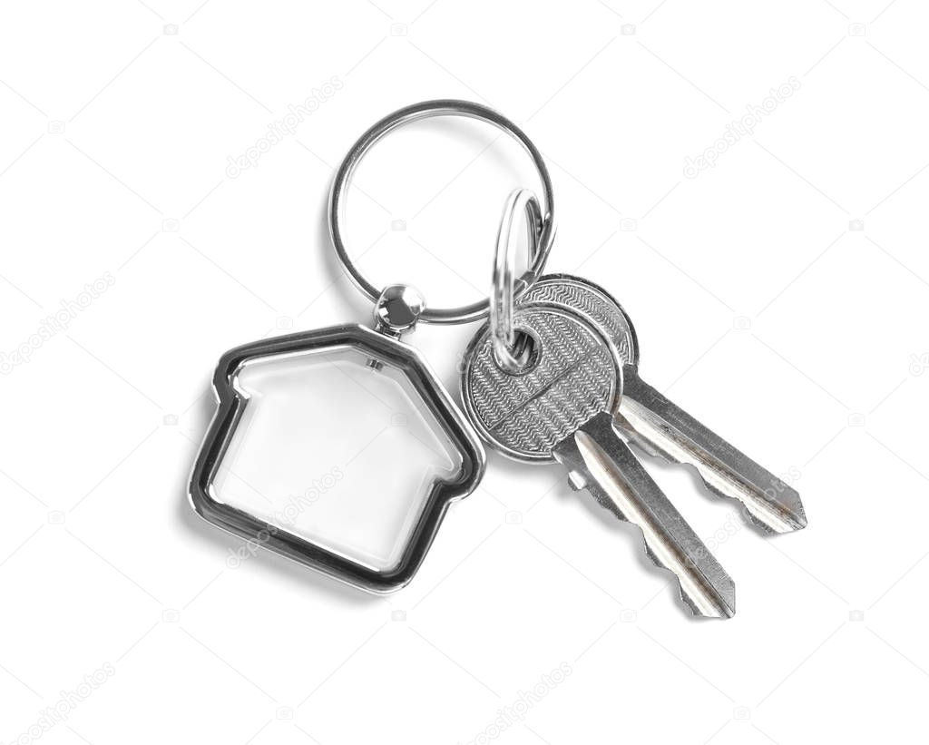 House keys with trinket on white background, top view