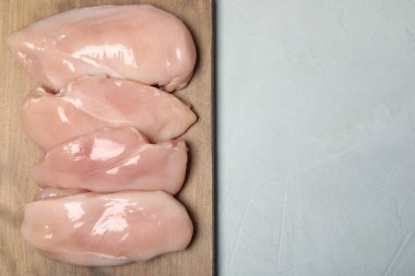 Ahşap tahta çiğ tavuk etli gri arka plan, üstten görünüm. Metin için yer