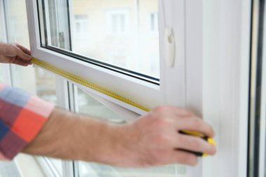 İnşaat işçisi closeup Plastik pencere kapalı, ölçme. Profesyonel kurulum