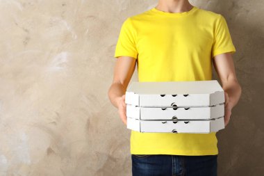 Pizza kutuları renk arka plan, metin için yer üzerinde olan genç adam. Gıda dağıtım hizmeti