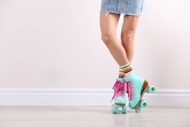 Beyaz duvar, closeup yakınındaki retro tekerlekli paten genç kadınla. Metin için yer