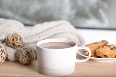 Pencere yakınındaki ahşap masa üzerinde aromatik kakao fincan