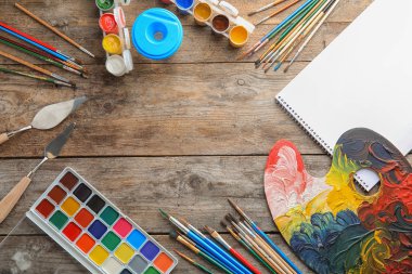 Farklı boyalar, fırçalar ve ahşap arka plan renk paletinde düz yatıyordu kompozisyonu. Metin için yer