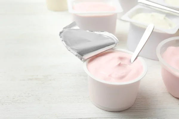 Taza Plástico Con Yogur Fresco Cuchara Sobre Mesa Madera Blanca — Foto de Stock