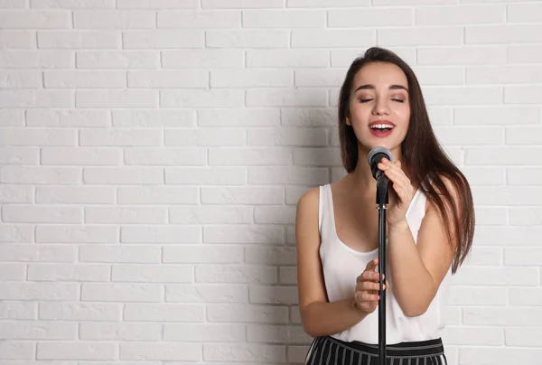 Молода Жінка Повсякденному Одязі Співає Мікрофоні Біля Цегляної Стіни Простір — стокове фото