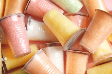 Arka plan, üstten görünüm olarak pamuk şeker ile plastik bardak 