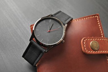 Şık kol saati ve cüzdanı koyu arka plan üzerinde. Moda aksesuar