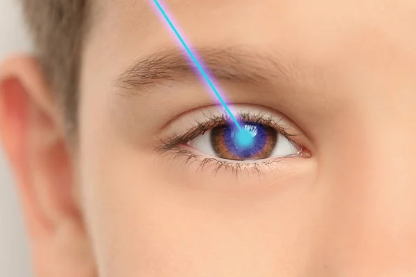 Laser and little boy, closeup of eye. Visiting ophthalmologist for vision correction