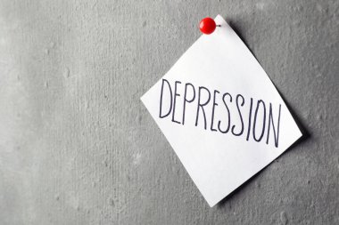 Kağıt Not yazılı kelime depresyon ile gri duvara sabitlenmiş. Metin için yer