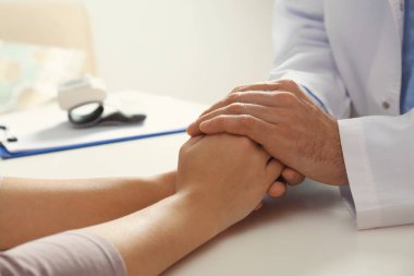 Erkek doktor kadın masada, closeup el rahatlatıcı. Yardım ve destek kavramı