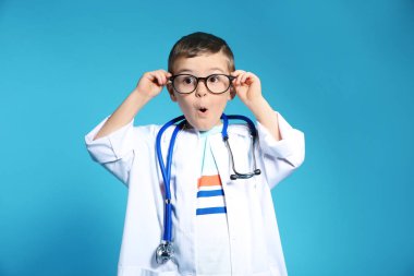 Doktor ceket renk arka plan üzerinde stetoskop ile şirin çocuk