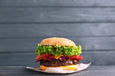 Ahşap arka plan karşı masada pastırma ile lezzetli burger