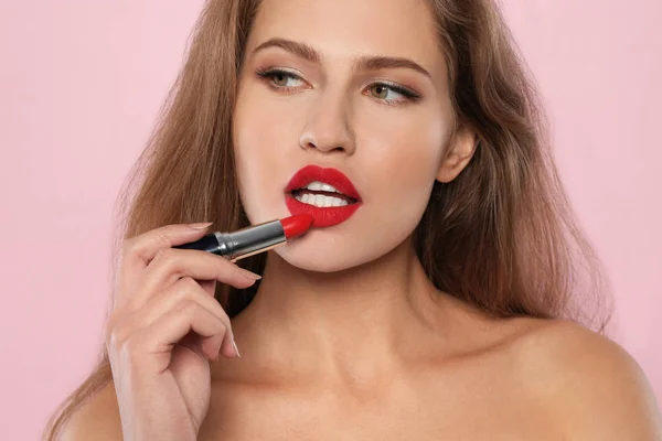 Mujer Joven Aplicando Lápiz Labial Rojo Sobre Fondo Color —  Fotos de Stock