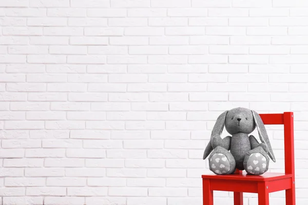 Teddy bear and rug on floor in child room. Space for text