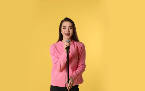 Genç Kadın Rahat Kıyafetler Renk Arka Plan Üzerinde Mikrofon Ile — Stok fotoğraf