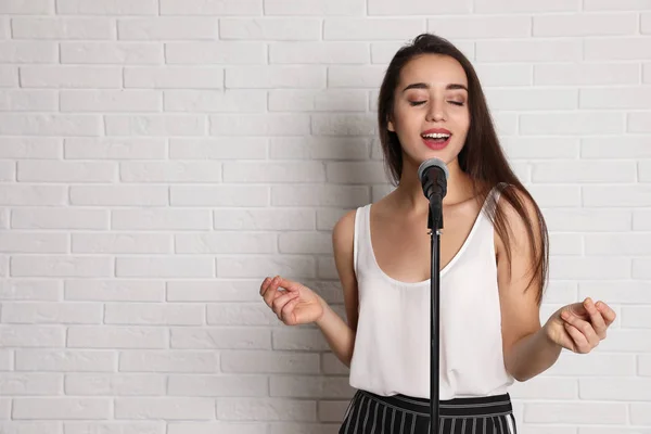 Молода Жінка Повсякденному Одязі Співає Мікрофоні Біля Цегляної Стіни Простір — стокове фото