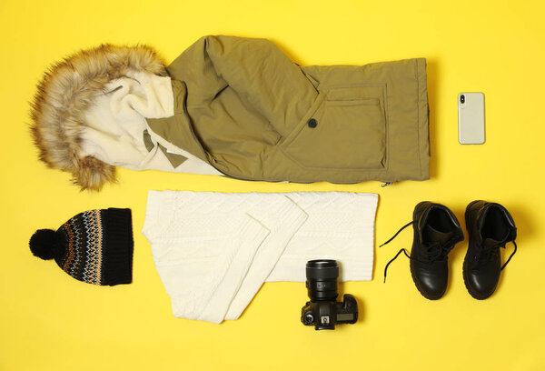 Flat lay composition with warm female clothes for winter vacation on color background