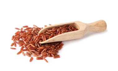 Kepçe ve beyaz arka plan üzerinde kahverengi pirinç pişmemiş