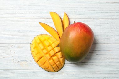 Beyaz ahşap zemin üzerinde olgun mango ile düz yatıyordu kompozisyon