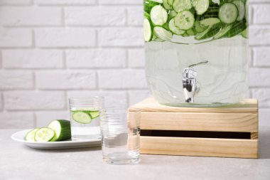 Taze salatalık suyu ve gözlük duvara karşı masada Klozette dispenser kavanoz. Metin için yer