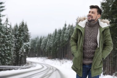 Snowy orman, metin için yer yakınındaki sıcak giysiler adam. Kış tatili