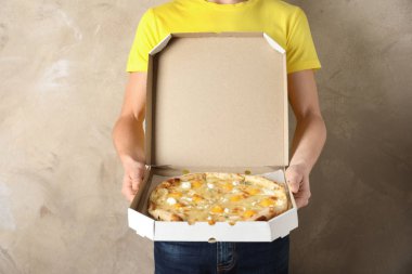 Açılan pizza kutusu renk arka plan üzerinde olan genç adam. Gıda dağıtım hizmeti