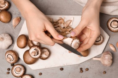 Genç kadın soyma taze champignon mantar, üstten görünüm