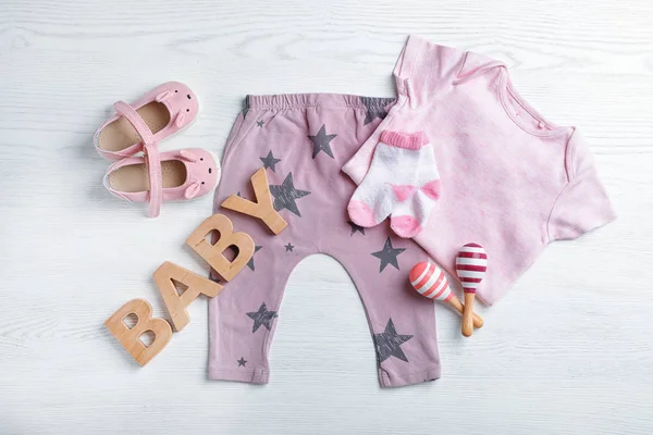 Plat Lag Samenstelling Met Leuke Kleren Witte Houten Achtergrond Baby — Stockfoto