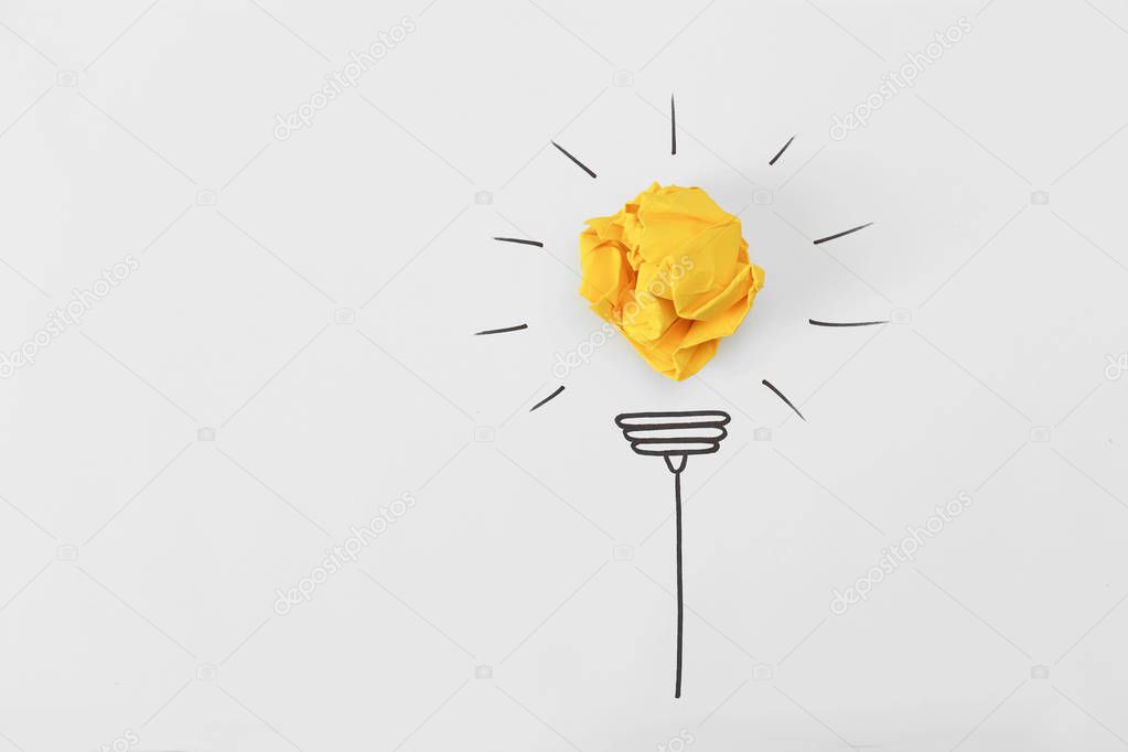 Composition with crumpled paper ball, drawing of lamp bulb and space for text on white background, top view. Creative concept