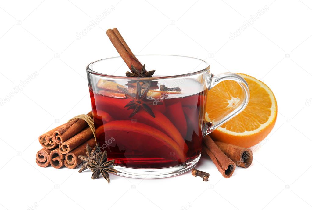 Glass cup of mulled wine, fresh orange and cinnamon sticks isolated on white
