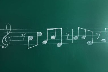Müzik personel tiz nota anahtarı ve kara tahta yazılı notlarla birlikte