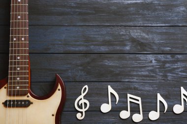 Müzik notlar ve ahşap arka plan, üstten görünüm gitarda. Metin için yer