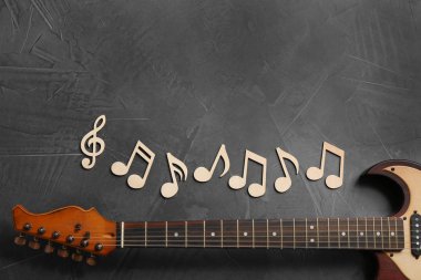 Müzik notlar ve gitar boyun gri arka plan, üstten görünüm üzerinde. Metin için yer