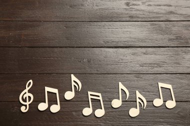 Müzik notlar ve tiz nota anahtarı ahşap arka plan, üstten görünüm üzerinde. Metin için yer