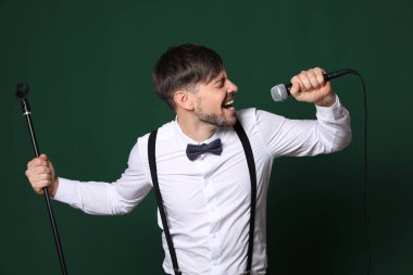 Resmi kıyafetler renk arka plan üzerinde mikrofon ile şarkı yakışıklı adam