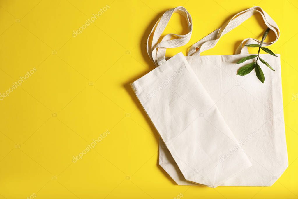 Flat lay composition with eco tote bags and space for text on color background
