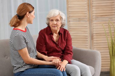 Yaşlı kadın ile erkek bakıcı oturma odasında. Metin için yer