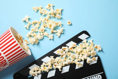 Patlamış mısır ve Klaket renk arka plan, üstten görünüm üzerinde. Sinema snack