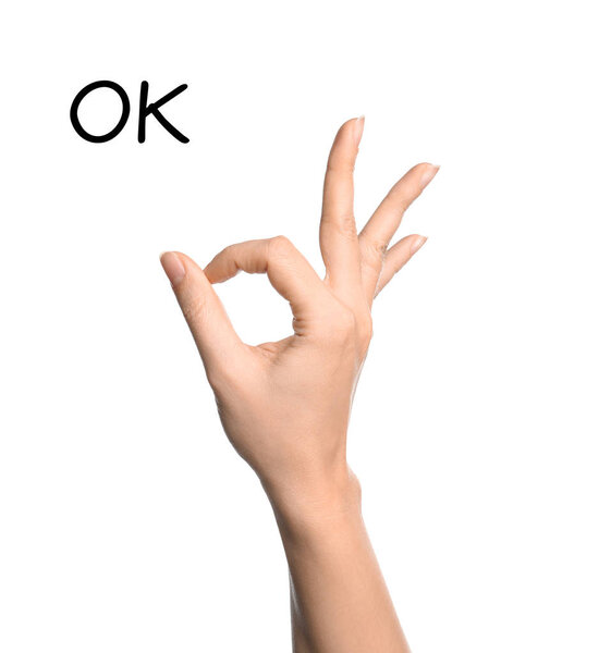 Woman showing word Okay on white background, closeup. Sign language