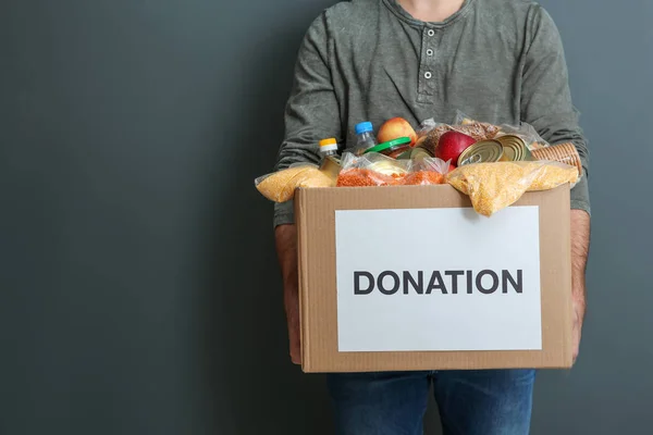 Hombre Sosteniendo Caja Donaciones Con Comida Sobre Fondo Gris Primer —  Fotos de Stock