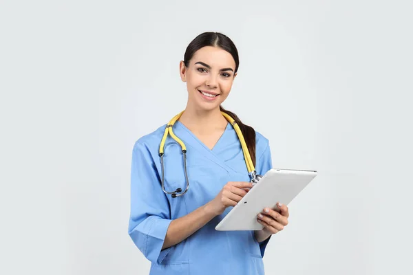 Retrato Assistente Médico Com Estetoscópio Tablet Fundo Claro — Fotografia de Stock