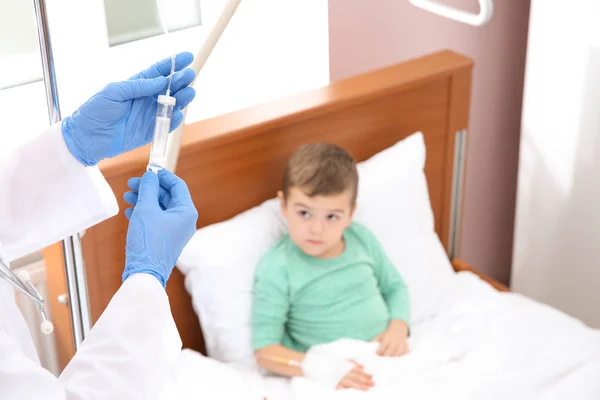 Little child with intravenous drip sleeping in hospital bed