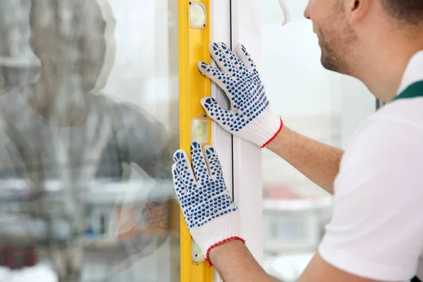 Byggnadsarbetare Med Vattenpass När Installerar Fönster Inomhus Närbild — Stockfoto