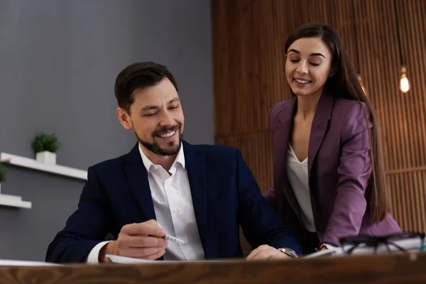 Office employees working with documents at table indoors