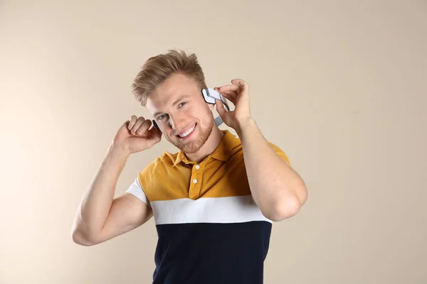 Przystojny Młody Człowiek Słuchanie Muzyki Przez Słuchawki Kolor Tła — Zdjęcie stockowe