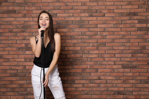 Wanita Muda Bergaya Bernyanyi Mikrofon Dekat Dinding Bata Ruang Untuk — Stok Foto
