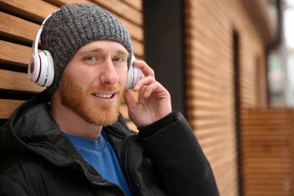 Jeune Homme Écoutant Musique Avec Casque Près Mur Bois Espace — Photo