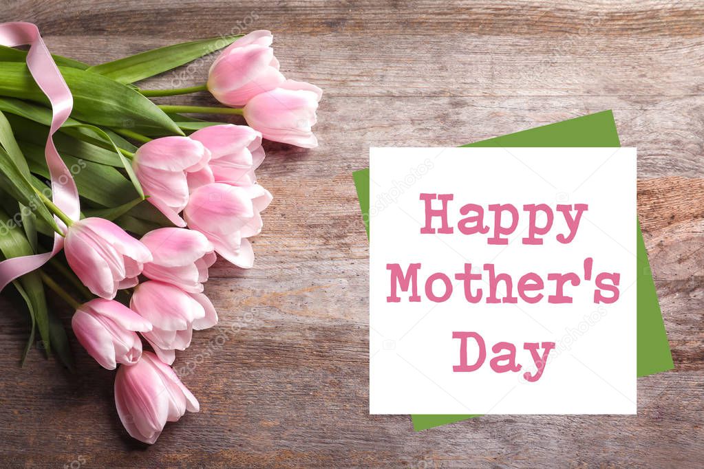 Beautiful tulips and text Happy Mother's Day on wooden background, top view